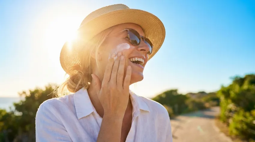 Ženska nanaša kremo za sončenje na prostem